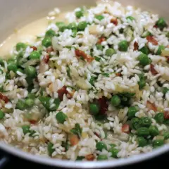 Risi e bisi, kremowe risotto z groszkiem i kawałkami boczku, gotowe do podania.