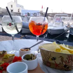 Aperol Spritz i drink z miętą, bruschetty, oliwki i chipsy nad wodą. Czego nie robić we Włoszech? Z pewnością nie przegapić takiej chwili!