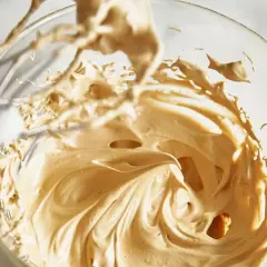 Puszysty krem kawowy w szklanej misie, ubijany mikserem. Idealny do deserów i kawy.