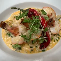 Kremowe risotto z krewetkami, ozdobione papryczką chili i kiełkami. Idealne danie, do którego użyto aromatycznego bulionu do risotto.