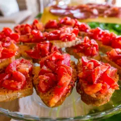 Pyszna bruschetta al pomodoro na chrupiących grzankach, udekorowana świeżymi pomidorami i ziołami. Idealna przekąska.