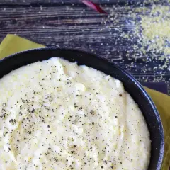 Kremowa polenta w czarnej patelni, posypana pieprzem. Ten prosty polenta przepis to kwestia smaku, idealny na szybki obiad.
