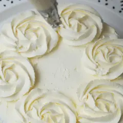 Tort ozdobiony kremem mascarpone w kształcie różyczek. Delikatny, puszysty krem zachęca do spróbowania.