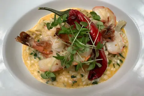 Kremowe risotto z krewetkami, ozdobione papryczką chili i kiełkami. Idealne danie, do którego użyto aromatycznego bulionu do risotto.
