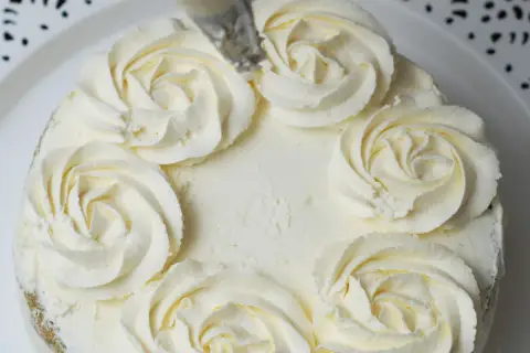 Tort ozdobiony kremem mascarpone w kształcie różyczek. Delikatny, puszysty krem zachęca do spróbowania.