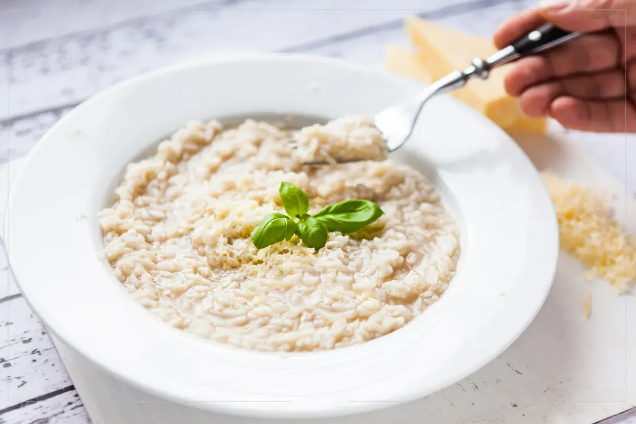 Kremowe risotto z parmezanem i bazylią, idealne do przygotowania w domu. Dowiedz się, jak ugotować ryż do risotto.