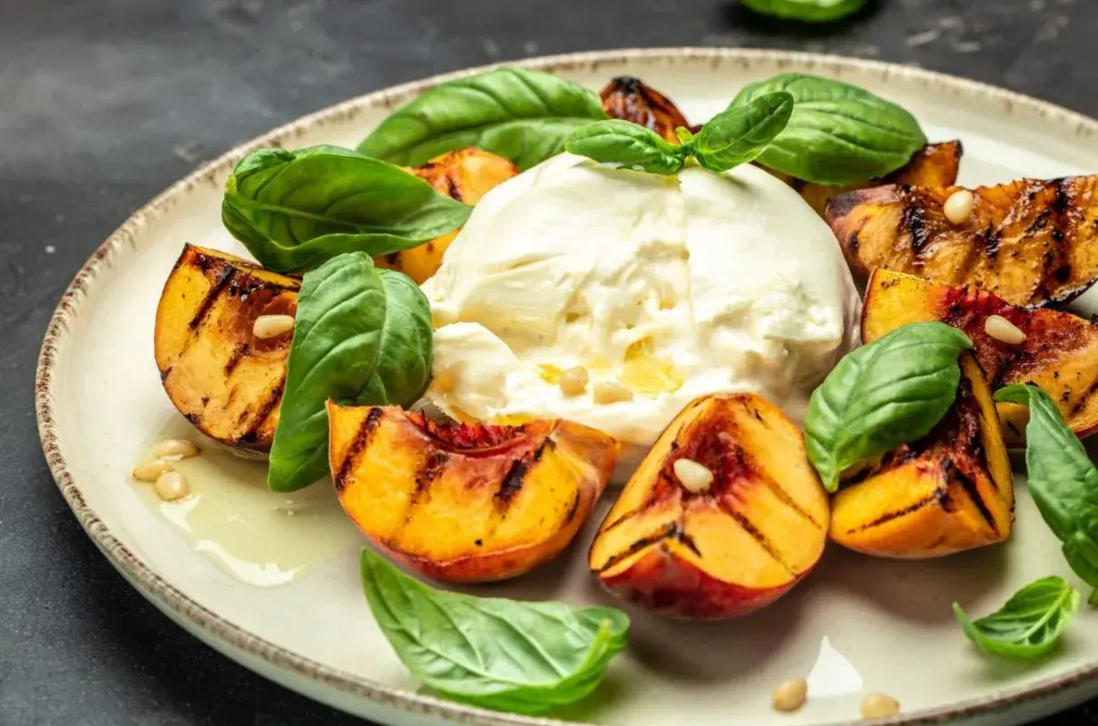 Pyszny **burrata przepis** z grillowanymi brzoskwiniami, świeżą bazylią i orzeszkami pinii. Idealna letnia przekąska.