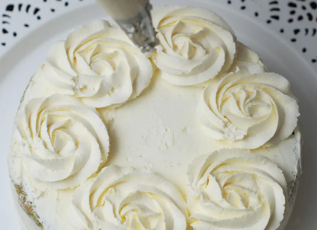 Tort ozdobiony kremem mascarpone w kształcie różyczek. Delikatny, puszysty krem zachęca do spróbowania.