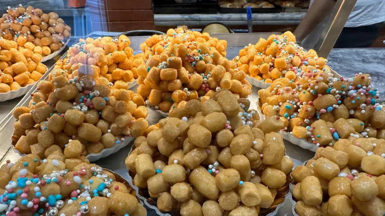 Struffoli, tradycyjne włoskie słodkości, ozdobione kolorowymi posypkami, idealne na Boże Narodzenie we Włoszech.