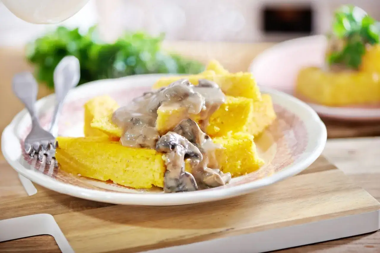 Kawałki polenty z kremowym sosem grzybowym. Idealne połączenie, gdy zastanawiasz się, polenta z czym jeść.