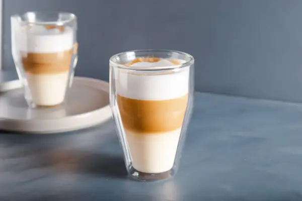 Dwa warstwowe latte macchiato w szklankach z podwójnymi ściankami, idealne na spokojny poranek.