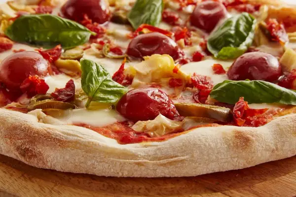 Pyszna pizza z pomidorkami, bazylią i ciągnącym się **serem mozzarella**. Idealna na letni wieczór.